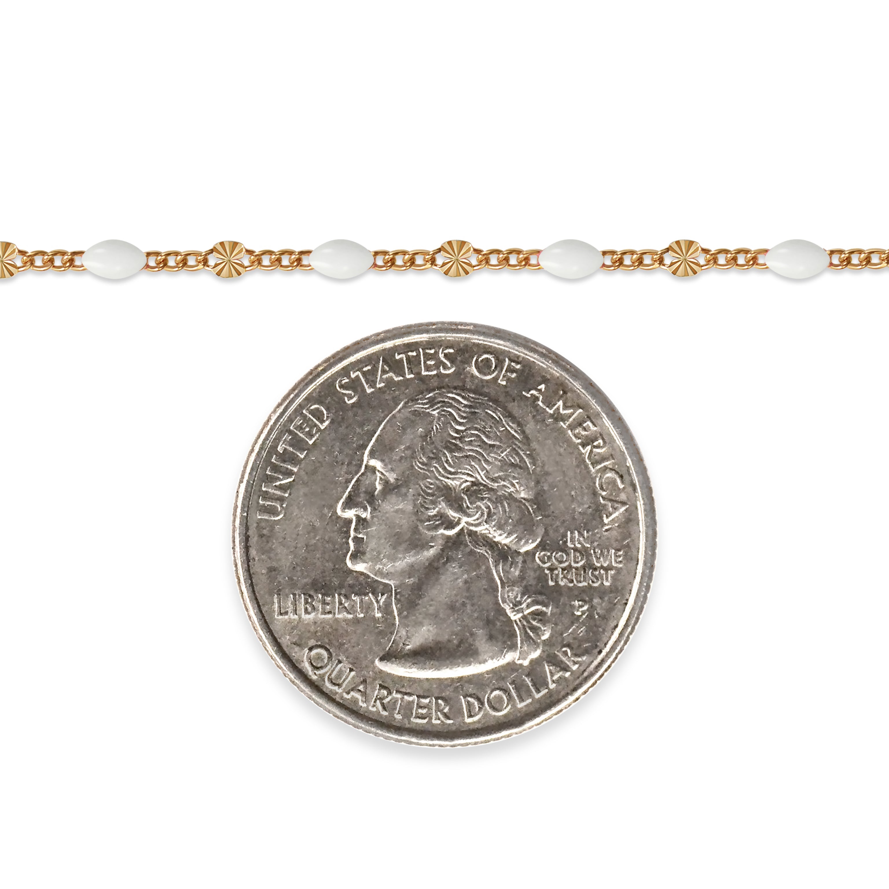 Gold filled chain with white enamel next to a quarter on a white background