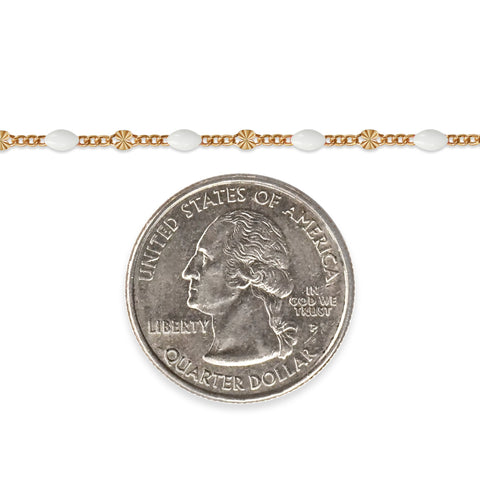 Gold filled chain with white enamel next to a quarter on a white background