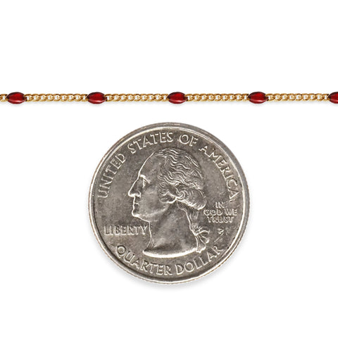 Gold filled chain with red enamel on a white background next to a quarter for scale