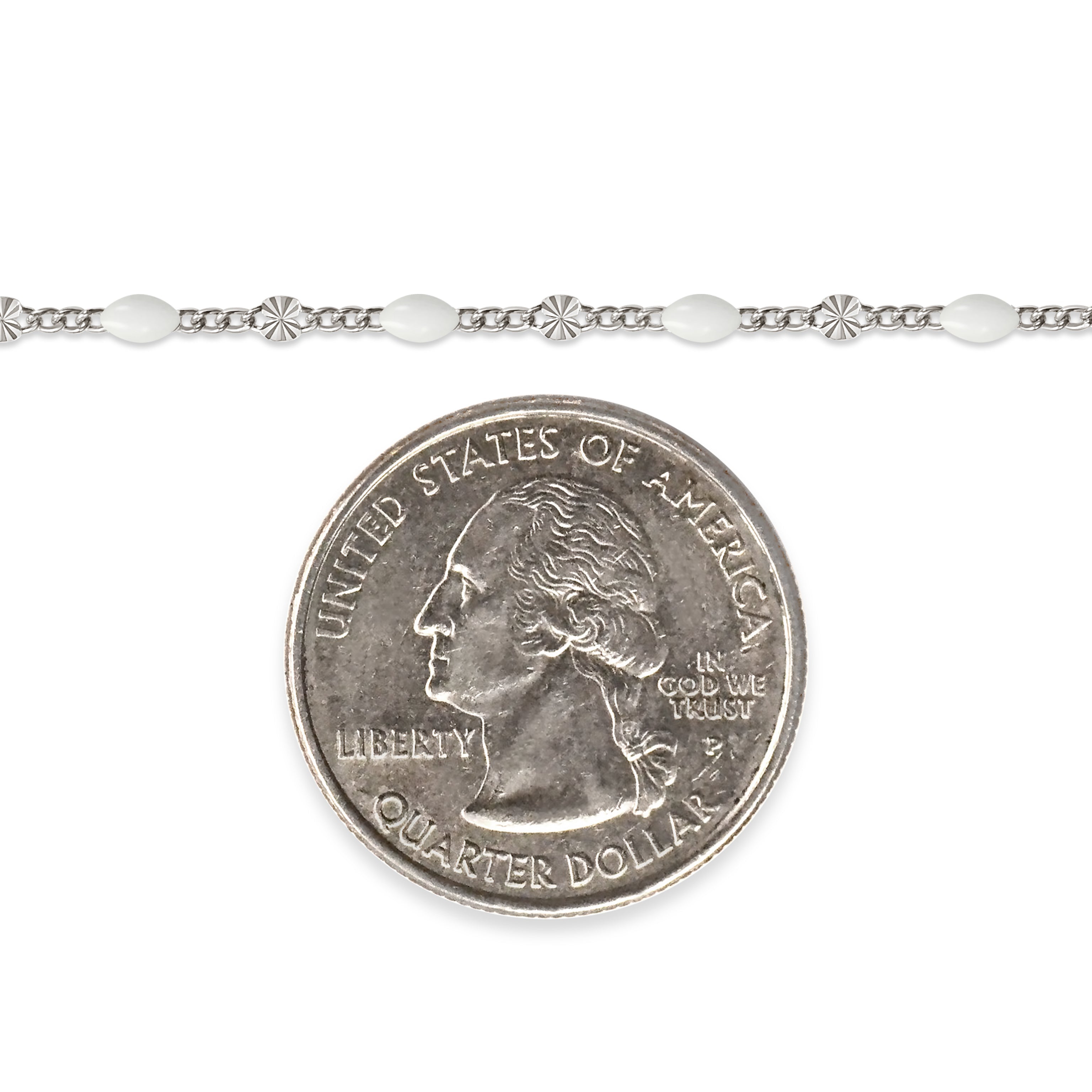 Sterling silver chain with white enamel next to a quarter