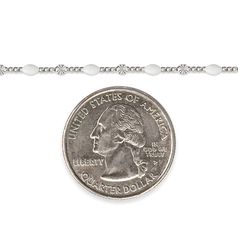 Sterling silver chain with white enamel next to a quarter