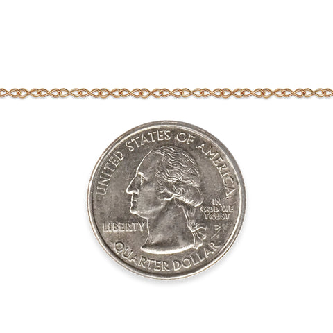 Gold-filled infinity chain next to a quarter dollar coin for scale on a white background