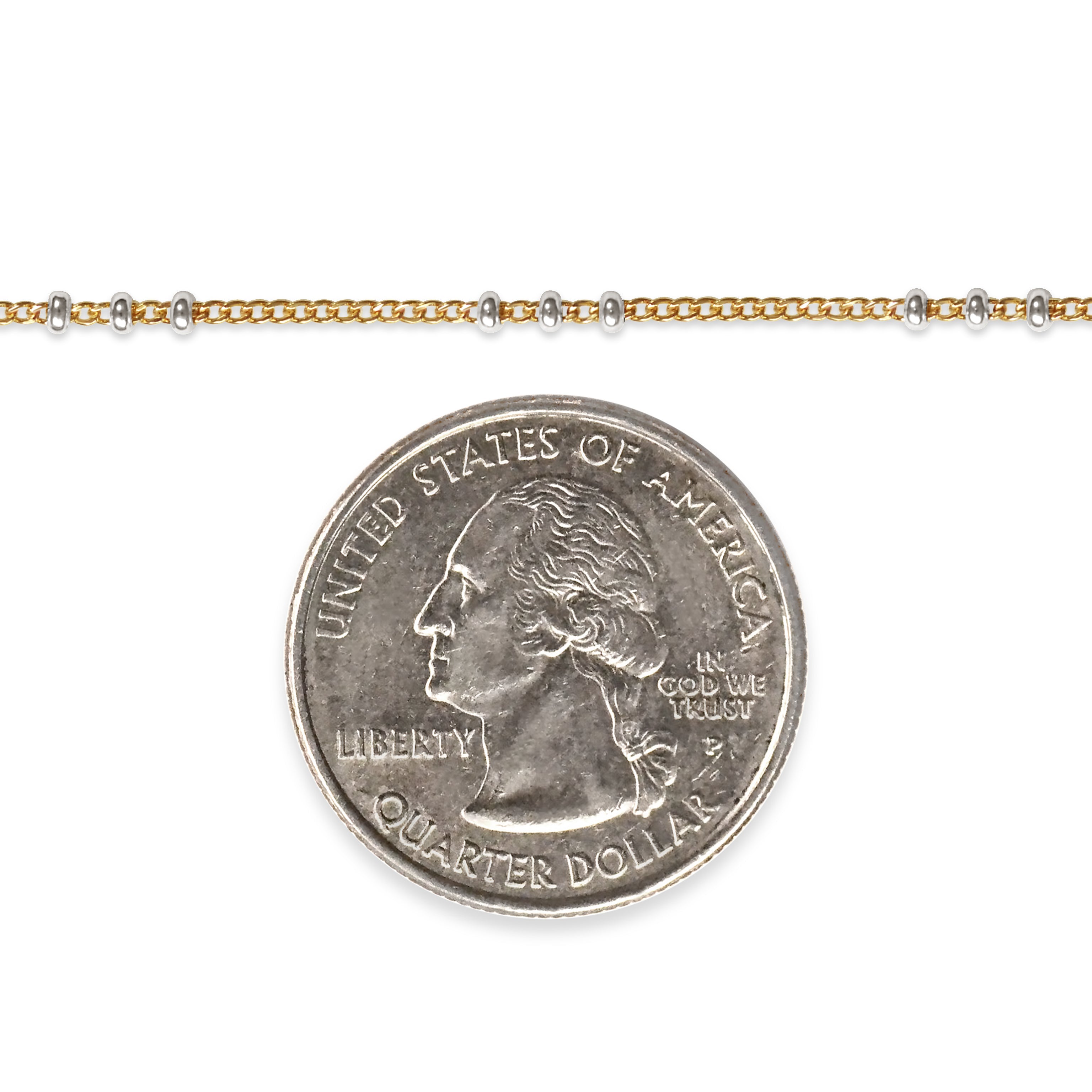 Two tone chain next to a quarter dollar coin on a white background