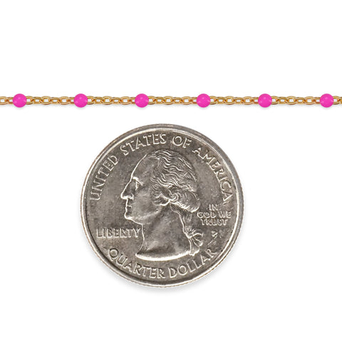 Gold chain with pink beads and a quarter coin on a white background