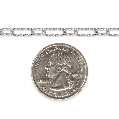 Diamond-cut sterling silver chain next to a quarter dollar coin on a white background