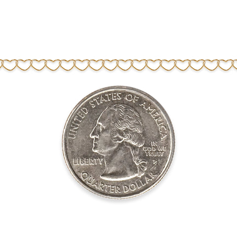 Gold-filled heart chain next to a quarter dollar coin on a white background