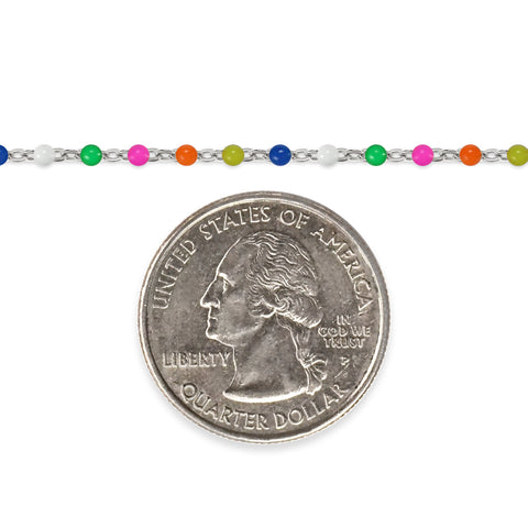 Silver chain with multicolored beaded enamel and a quarter for scale on a white background