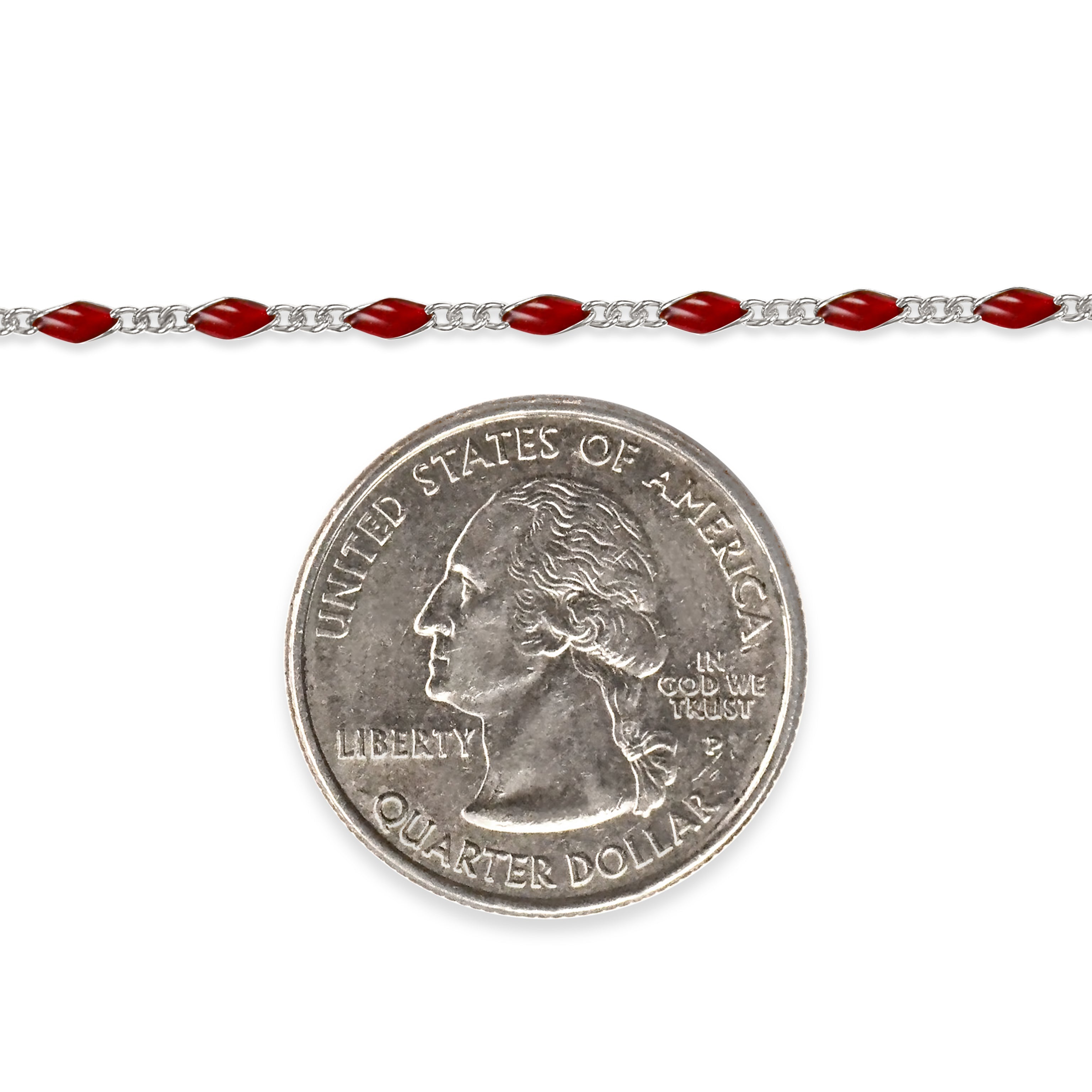 Sterling silver chain with red enamel next to a quarter dollar coin on a white background