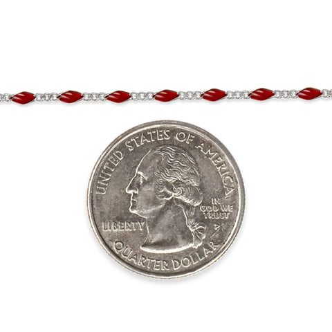 Sterling silver chain with red enamel next to a quarter dollar coin on a white background