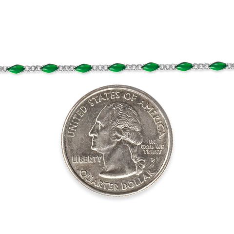 Sterling silver chain with green enamel next to a quarter dollar coin on a white background