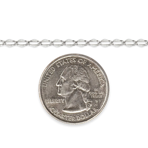 Silver chain with white enamel next to a quarter on a white background
