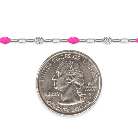 Silver chain with pink enamel next to a quarter on a white background