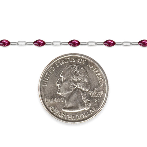 Silver chain with fuchsia colored enamel next to a quarter for scale on a white background