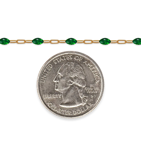 Gold filled chain with green enamel next to a quarter on a white background