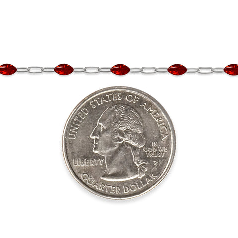 Silver chain with red enamel next to a quarter for scale on a white background