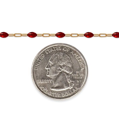 Gold filled chain with red enamel next to a quarter on a white background